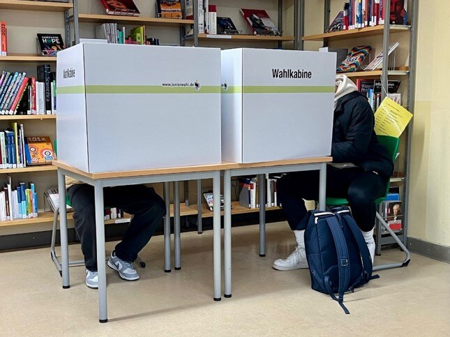 Foto: Schüler wählen in der Wahlkabine.